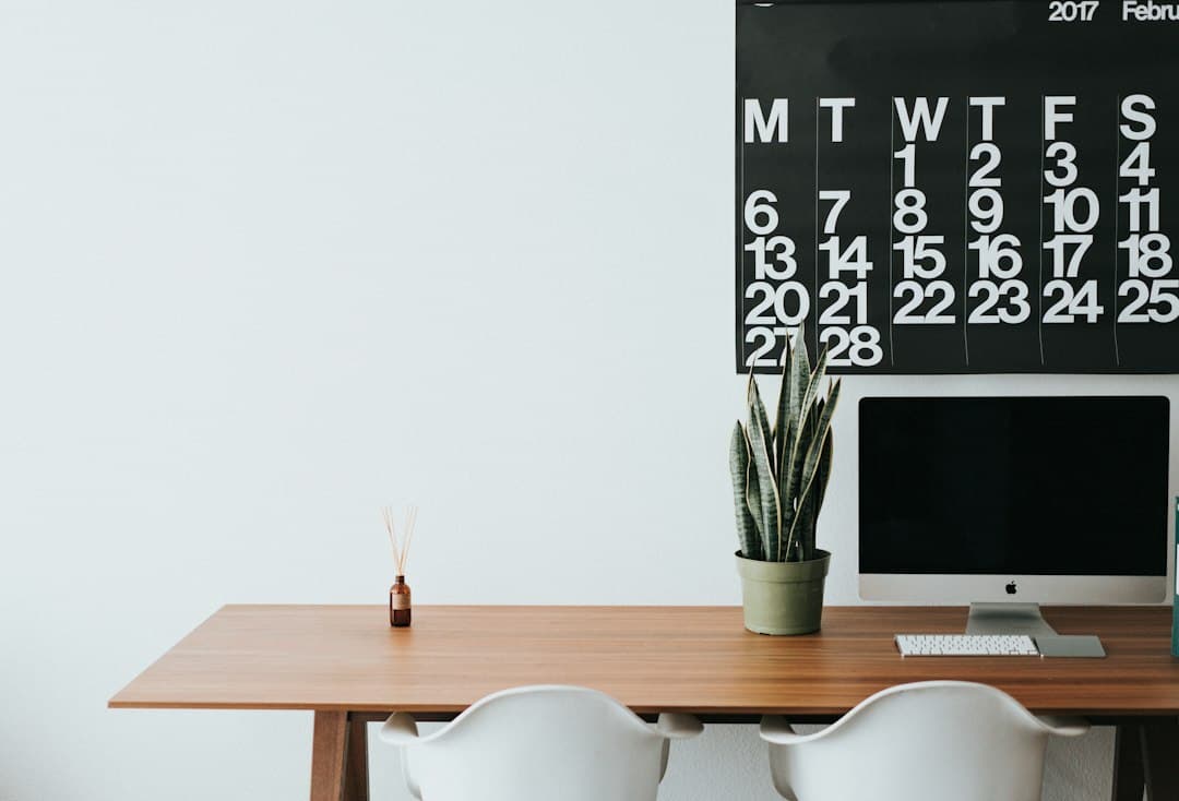 A wall calendar above a desk with a computer and a plant, planning a monthly Digitaline IPTV subscription
